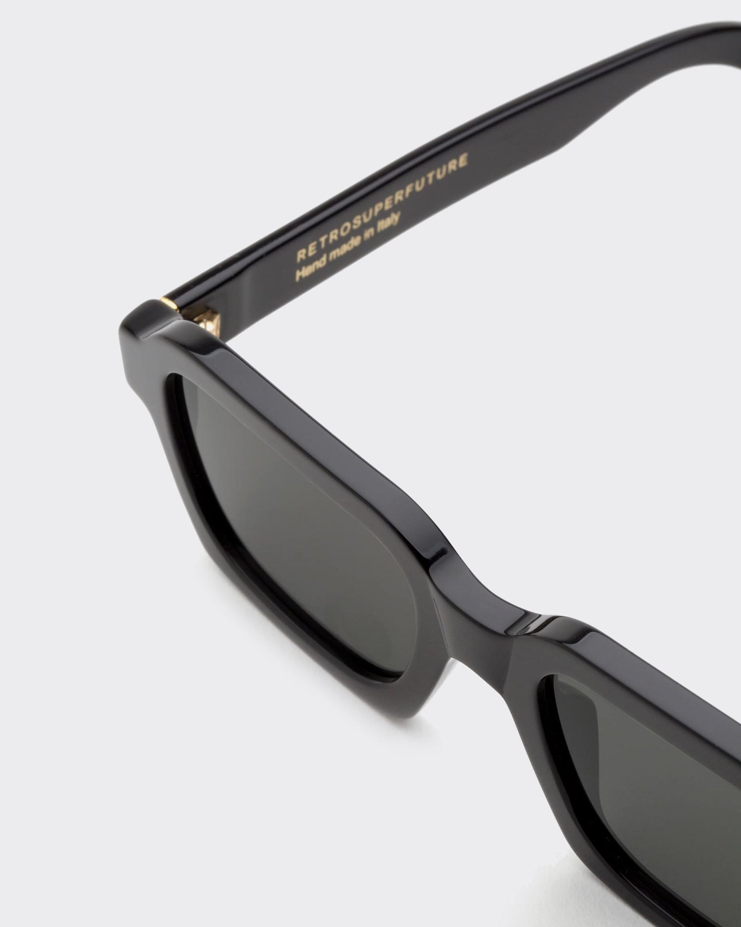 Black sunglasses with 'Retrosuperfuture' branding on a light gray background