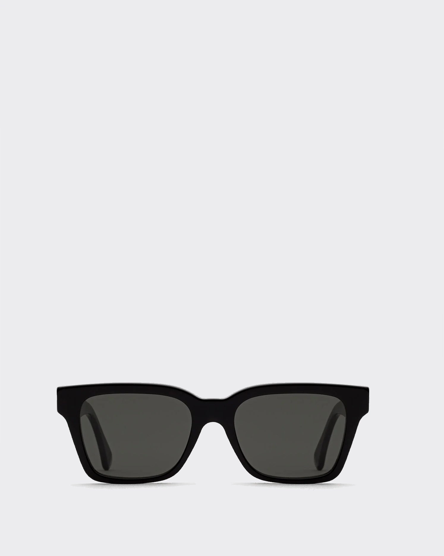 Black sunglasses with dark lenses on a light gray background gold accent