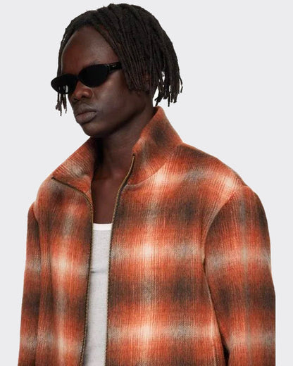 Person wearing a plaid jacket with a neutral background