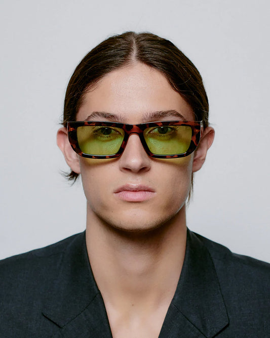 Person wearing sunglasses with a neutral background