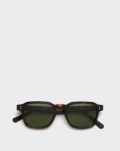 Sunglasses with tortoiseshell frame and green lenses on a light gray background