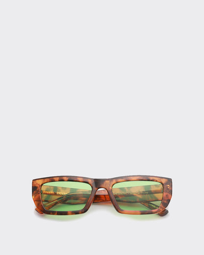 Tortoiseshell sunglasses with green lenses on a light gray background